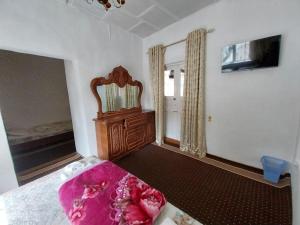 撒马尔罕Fayz Guest House的一间卧室配有一张床、镜子和窗户