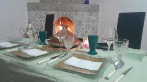 马拉喀什Hostel artistic airport的一张桌子,上面有盘子和玻璃杯,上面有台灯