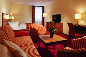 萨克森自由州诺伊斯塔滕新斯塔德特公园酒店的酒店客房设有沙发、床和桌子。