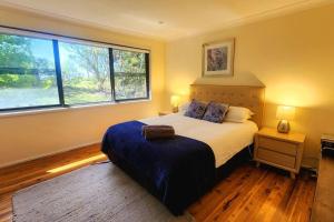 肯图巴Narrow Neck Views - Peaceful 4 Bedroom Home with Stunning Views!的一间卧室设有一张大床和两个窗户。