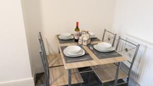 NelsonReedley House的一张桌子,上面放有盘子和一瓶葡萄酒