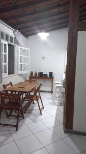 盖比姆Praia de Guaibim - Casa de praia 2Q - 2 suítes com ar - em condomínio a 300m da praia的一间带木桌和椅子的用餐室