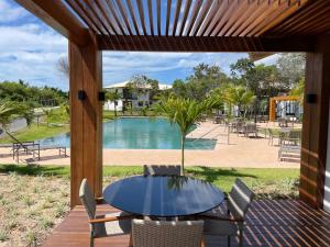 马塔迪圣若昂Apartamento Praia do Forte的一个带桌椅的庭院和一个游泳池