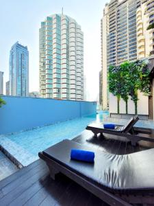 曼谷康帕斯酒店集团素坤逸13巷娜娜柑橘酒店的阳台设有游泳池和桌子,部分建筑设有