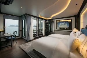 下龙湾Lapinta Luxury Cruises的一间卧室配有一张大床、一张书桌和窗户。