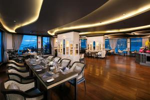 下龙湾Lapinta Luxury Cruises的一间带桌椅的海景餐厅