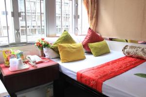 香港London Guest House的酒店客房配有两张带色彩缤纷枕头的床。