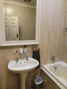 布隆方丹LemonBlossom的浴室配有盥洗盆、镜子和浴缸