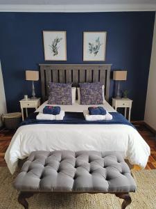 布隆方丹LemonBlossom的一间卧室设有一张蓝色墙壁的大床