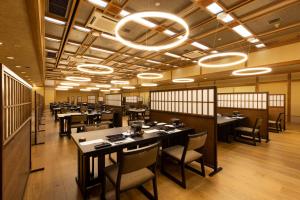 中之条志摩亚马赤坎日式旅馆的用餐室配有桌椅和灯光