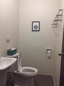 CogonMactan Airport Guesthouse的浴室配有白色卫生间和盥洗盆。