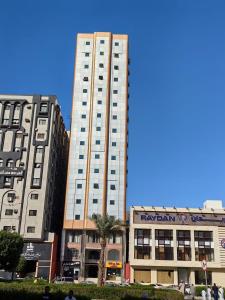 麦加فندق نبض الضيافة 1 - العزيزية الشارع العام的两座建筑前方高大的白色建筑
