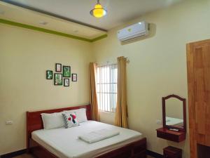 潘郎Đức Chính Hotel - Ninh Chu - Phan Rang的一间卧室配有一张床、镜子和窗户