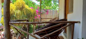 马特姆维Morningstar Bungalows Zanzibar的鲜花门廊上的木摇椅
