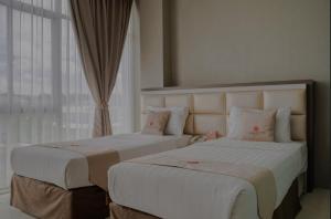 名古屋Osaka Hotel Batam的配有窗户的酒店客房内的两张床