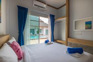 奥南海滩Amadha Villas Retreat - Free Tuk-Tuk Service To the Beach的一间卧室设有一张床和一个大窗户
