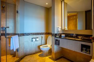 哥打京那巴鲁太平洋丝绸酒店的一间带卫生间、水槽和镜子的浴室