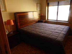 波尔图海滩公寓的一间卧室设有一张大床和一个窗户。