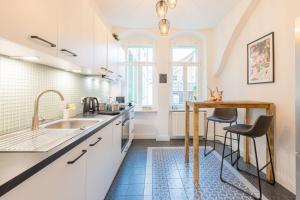 梅森Fynbos Apartments Theaterblick, Netflix, Parkplatz的厨房配有白色橱柜、水槽和桌子