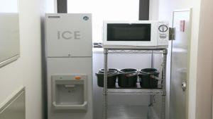 盛冈HOTEL BRIGHT INN MORIOKA的冰箱旁的架子上的一个微波炉