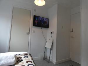 梅瑟蒂德菲尔Bridge Street En Suite Rooms的卧室配有一张床,墙上配有电视