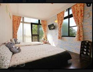 古坑華山禾園親子民宿的一间卧室设有两张床和大窗户