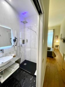 卡利亚里Antico Corso Charme的一间带玻璃淋浴和水槽的浴室