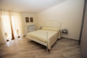 切塔拉Casa Landi的卧室配有白色的床,铺有木地板