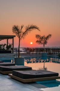 赫索尼索斯AKASHA Beach Hotel & Spa的享有日落美景的度假游泳池