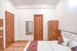 阿格拉FabHotel Sirtaj Suites的一间卧室设有一张床和木门