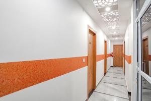 阿格拉FabHotel Sirtaj Suites的白色墙壁和橙色色调的办公走廊