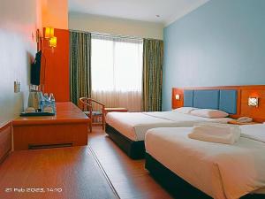 诗巫百乐门诗巫大酒店的酒店客房配有两张床和一张书桌