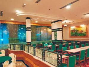 诗巫百乐门诗巫大酒店的一间餐厅,房间内设有绿色的椅子和桌子