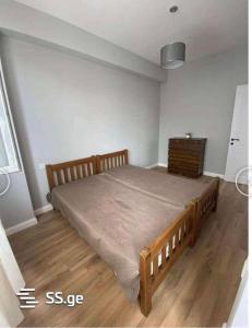 博尔若米Borjomi的一间卧室设有一张大床,铺有木地板