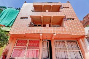 瓜廖尔SPOT ON Ganesh Guest House的一座橙色的建筑,窗户在建筑的一侧