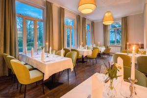 万根沃格Parkhotel Wangerooge的餐厅设有桌子和黄色的椅子以及窗户。