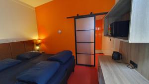 阿姆斯特丹Camping Zeeburg Amsterdam的一间卧室设有两张床和橙色的墙壁