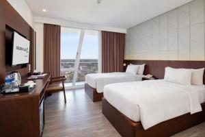 坤甸坤甸金色郁金香酒店的酒店客房设有两张床和一台平面电视。