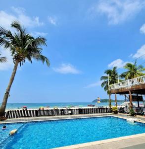 珍南海滩贝斯特星星酒店的棕榈树海滩旁的游泳池
