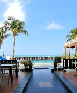 珍南海滩贝斯特星星酒店的毗邻大海的带桌子和棕榈树的天井