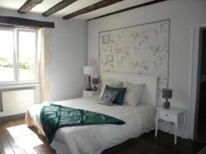 阿尔克昂巴鲁瓦Gîte et Chambres d'hôtes du Domaine du Val Bruant的白色的卧室设有一张大床和一个窗户
