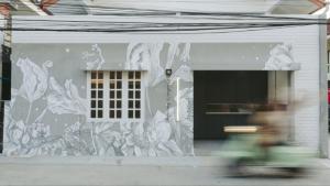 芭东海滩Dokdin's Family的骑着自行车穿过建筑壁画的人