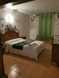 阿尔努埃罗拉玛莎旅馆的一间卧室配有床和绿帘