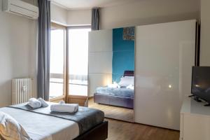 维罗纳[Arena-Fiera] Appartamento con vista panoramica的一间卧室配有一张床、一台电视和一张床
