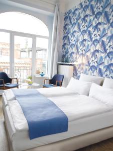 汉堡弗里茨普亚马酒店的一间卧室配有一张带蓝白色床单的大床