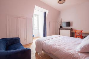 布尔日LE COURSARLON的一间卧室配有一张床和一张蓝色椅子