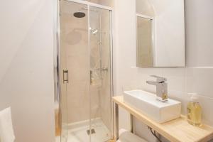 布尔日LE COURSARLON的带淋浴和盥洗盆的白色浴室