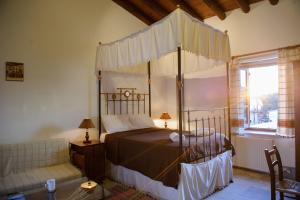 Maroni教师之家酒店的一间卧室配有天蓬床和沙发