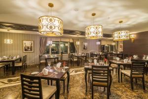 巴库Badamdar Hotel and Residences的用餐室配有桌椅和吊灯。
