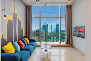 广州莱福仕行政公寓（广州正佳广场体育西路地铁站店）的客厅设有蓝色的沙发和大窗户